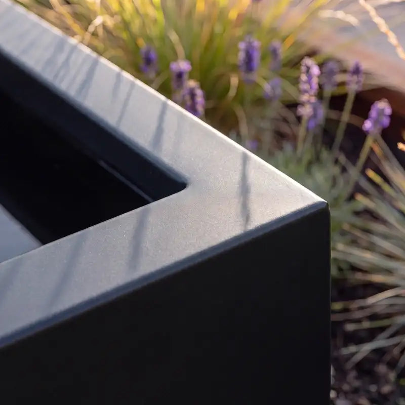 Detailbild von dem Oberrand eines Hochteichs aus Aluminium in einem modernen Garten.