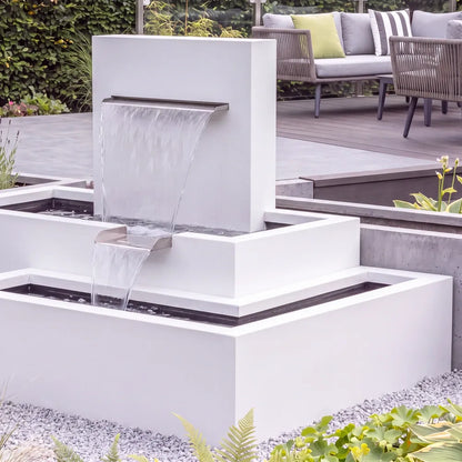 Modernes Wasserspiel mit einem stufigen Kaskadenbrunnen aus Aluminium in einem modernen Garten.