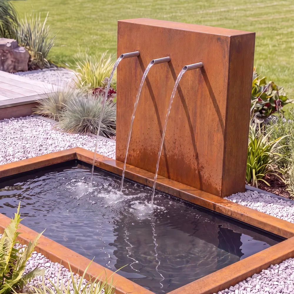 Metall-Wasserspiel mit einer Teichwand und Einlauf-Rohren mit einem im Boden versenktem GFK-Teichbecken.