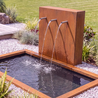 Metall-Wasserspiel mit einer Teichwand und Einlauf-Rohren mit einem im Boden versenktem GFK-Teichbecken.