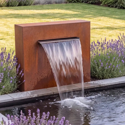 Teichwand aus Cortenstahl mit Wasserfall an einem einem Teichbecken im Garten.