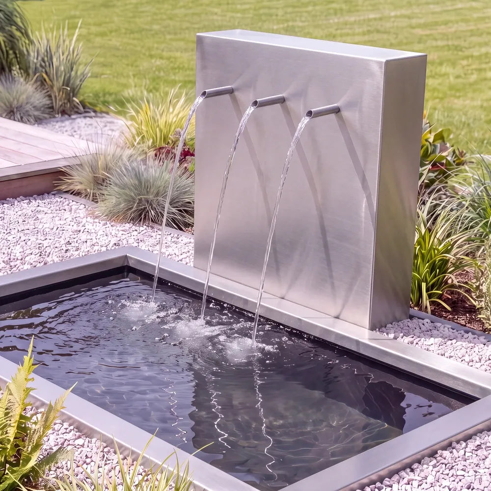 Metall-Wasserspiel mit einer Teichwand und Einlauf-Rohren mit einem im Boden versenktem GFK-Teichbecken.