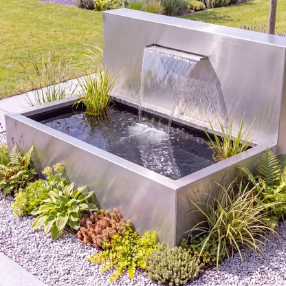 Hochteich aus Edelstahl mit freistehender Teichwand und Wasserfall in einem modernen Garten.