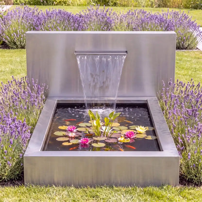 Teichwand aus Cortenstahl mit Wasserfall an einem einem Teichbecken im Garten.