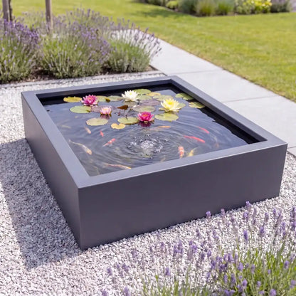 Großer quadratischer Teich aus Aluminium mit Fischen mit mediterranen Pflanzen in einem modernen Garten.