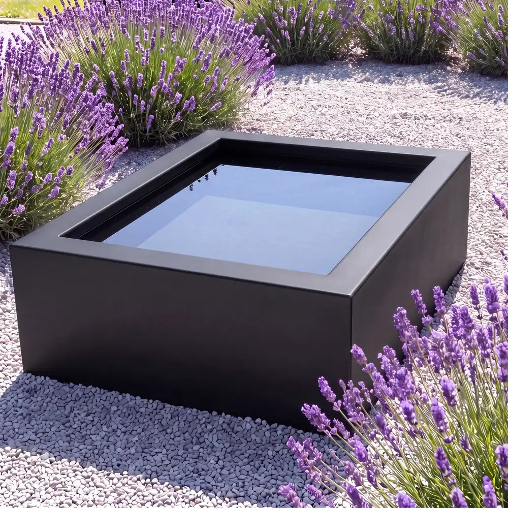 Aluminium-Hochteich in quadratischer Form mit spiegelnder Wasseroberfläche in einem minimalen Garten.