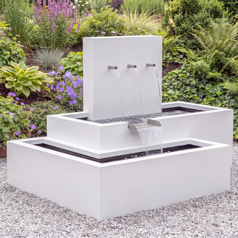Aluminium-Wasserkaskade mit drei Wasserausläufen als moderner Gartenbrunnen auf einer Kiesfläche im Garten.