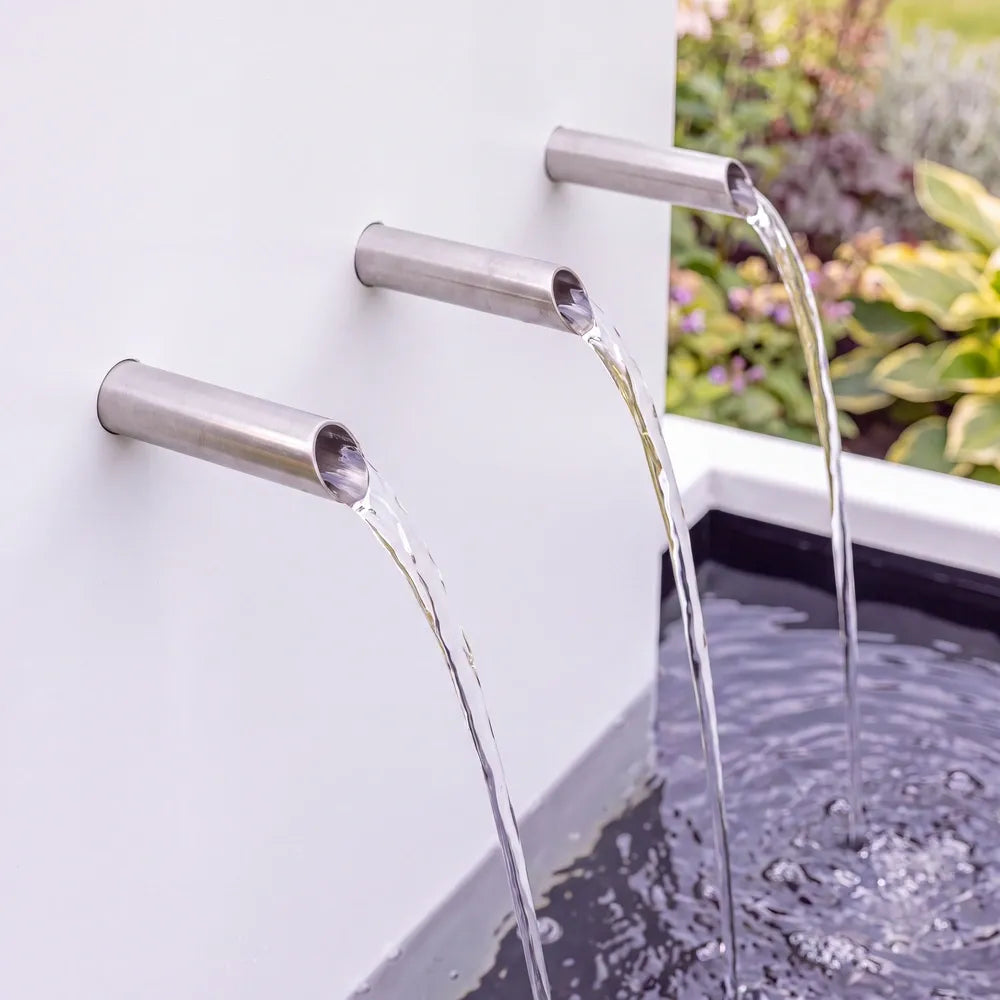 Edelstahl-Einlaufrohre an einer Wasserkaskade aus Aluminium mit mehrstufigen Teichbecken.