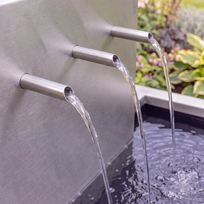 Edelstahl-Einlaufrohre an einer Wasserkaskade aus Edelstahl mit mehrstufigen Teichbecken.